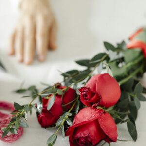 Crop person at table with flowers