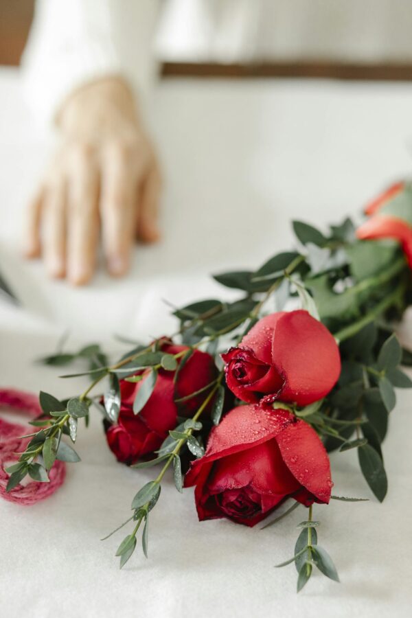 Crop person at table with flowers